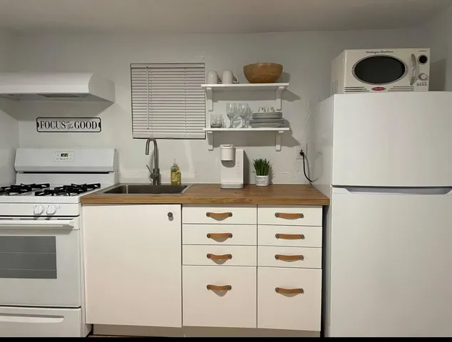 a kitchen with a refrigerator and white cabinets