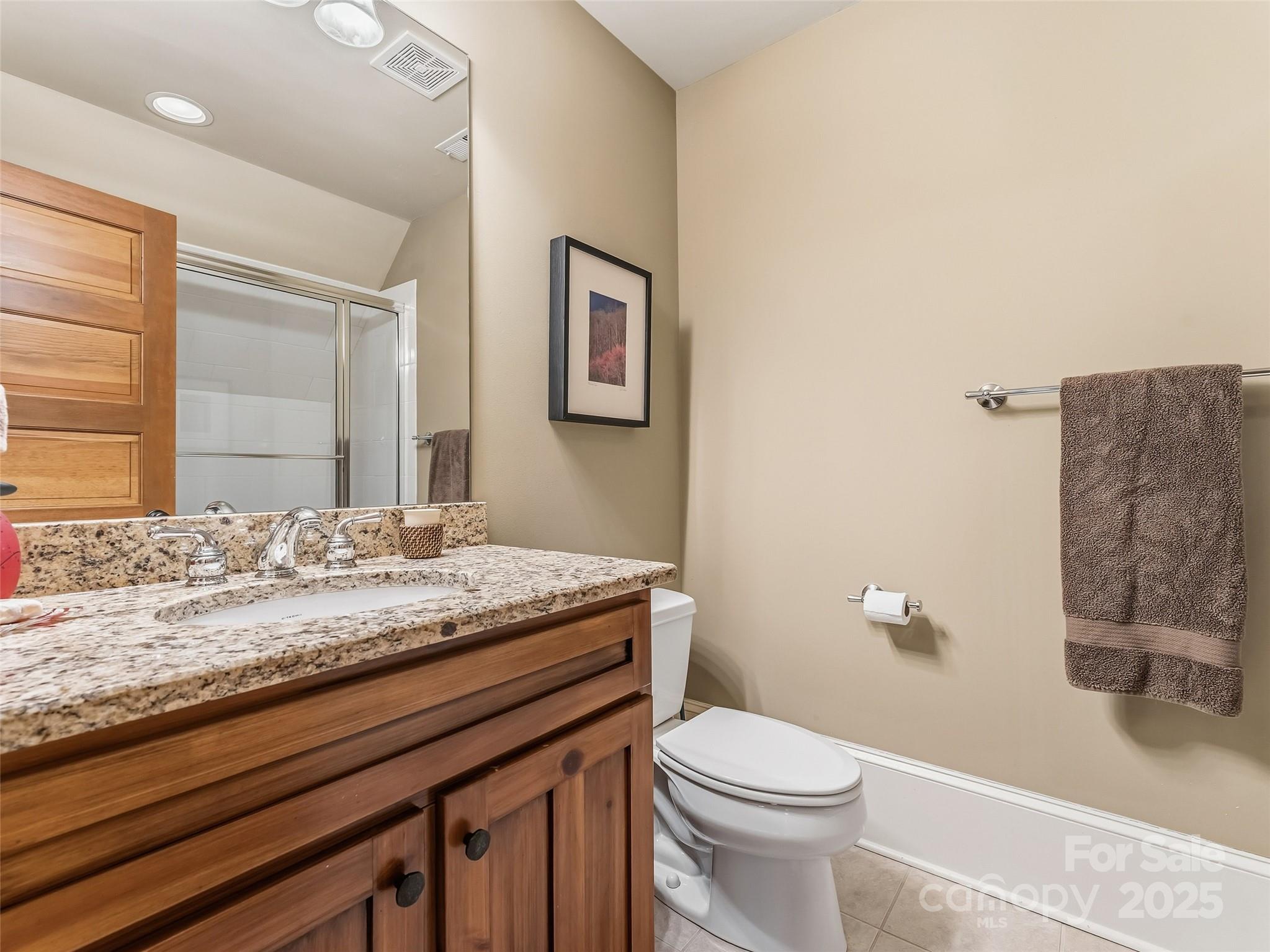 129 Ivy Ridge, Unit I26 Lake Toxaway, NC 28747 - Photo 20 of 39 a bathroom with a granite countertop sink a toilet and a mirror
