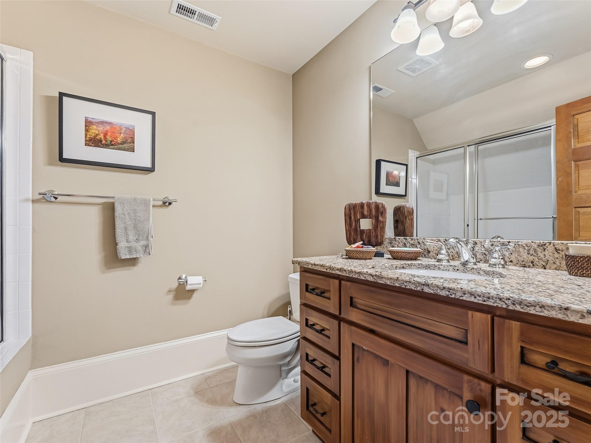 129 Ivy Ridge, Unit I26 Lake Toxaway, NC 28747 - Photo 22 of 39 a bathroom with a granite countertop toilet sink and mirror