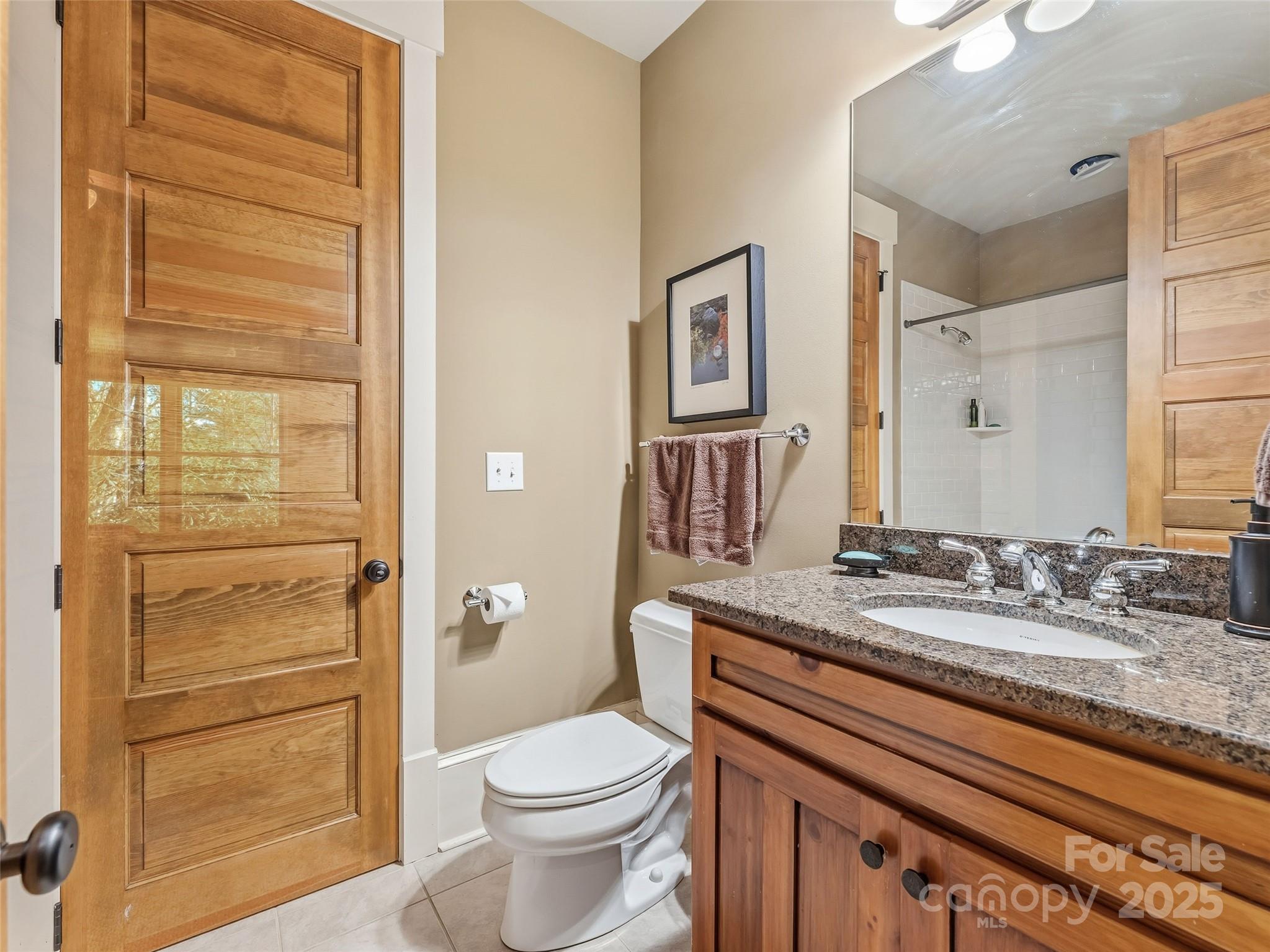 129 Ivy Ridge, Unit I26 Lake Toxaway, NC 28747 - Photo 26 of 39 a bathroom with a granite countertop toilet sink and a mirror