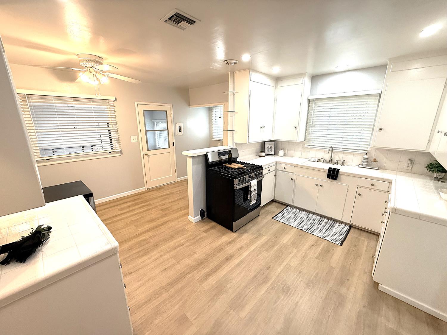 809 South Sowell Street Visalia, CA 93277 - Photo 22 of 58 a kitchen with stainless steel appliances kitchen island granite countertop a sink dishwasher a stove and white cabinets with wooden floor
