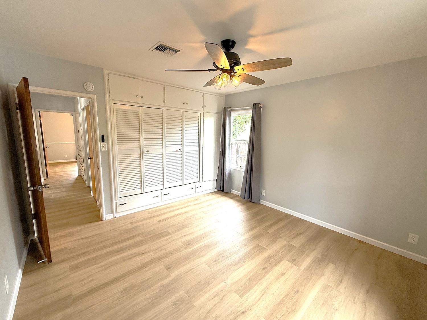 809 South Sowell Street Visalia, CA 93277 - Photo 34 of 58 a view of an empty room with wooden floor and a ceiling fan