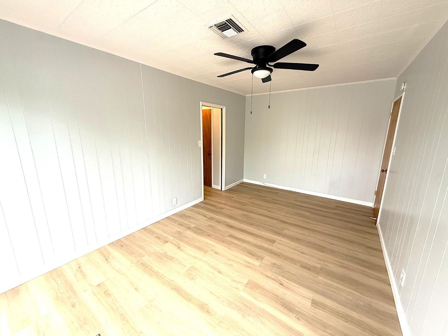 809 South Sowell Street Visalia, CA 93277 - Photo 40 of 58 a view of a big room with wooden floor and a ceiling fan