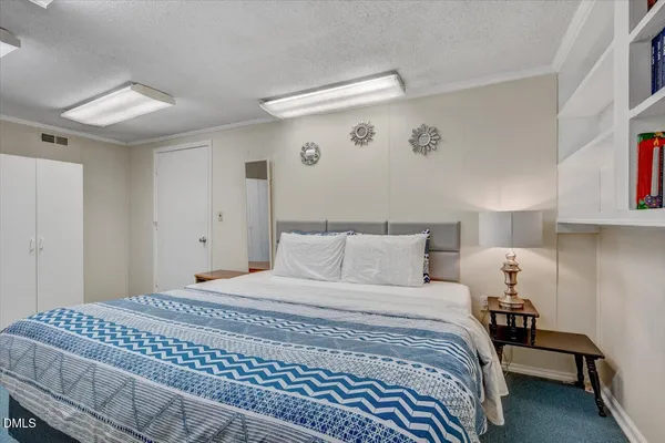 a bedroom with a bed and a lamp on dresser