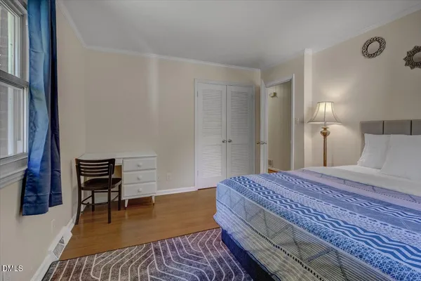 a bedroom with a bed and a chair with rug