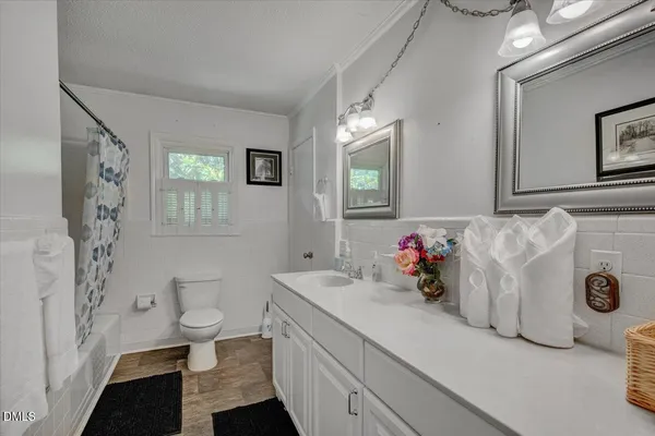 a bathroom with a sink toilet and window