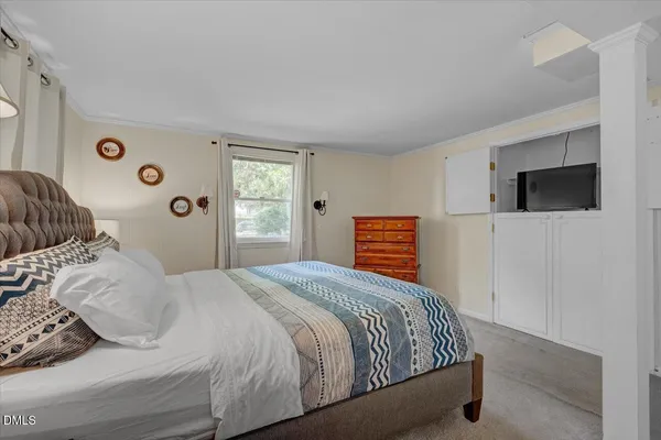 a bedroom with a large bed and a flat screen tv