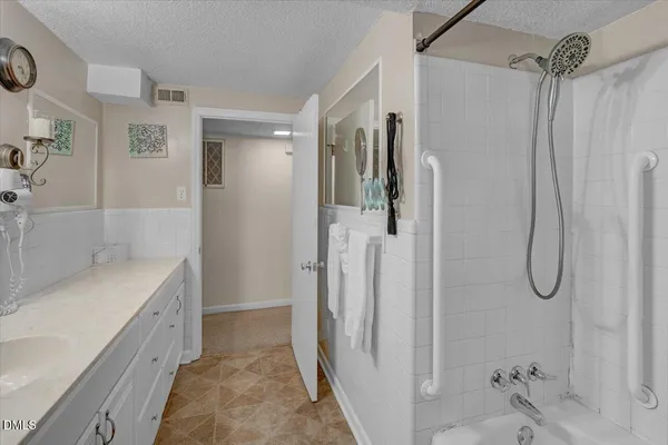 a bathroom with a tub sink and mirror