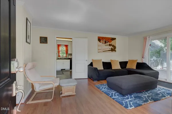 a living room with couches coffee table and chairs with wooden floor
