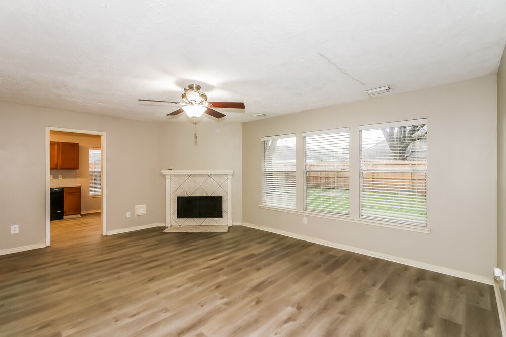 4635 Linden Place Pearland, TX 77584 - Photo 5 of 17 a view of an empty room with wooden floor fireplace and a window