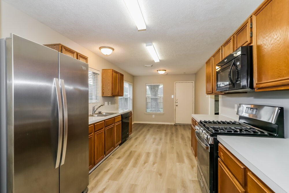4635 Linden Place Pearland, TX 77584 - Photo 9 of 17 a kitchen with stainless steel appliances granite countertop a refrigerator a stove and a sink