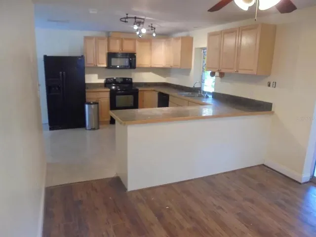 a kitchen with kitchen island white cabinets and refrigerator