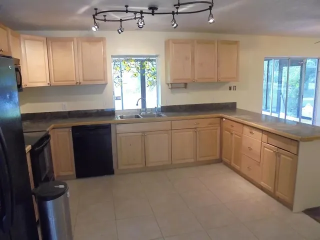 a kitchen with a sink window and cabinets