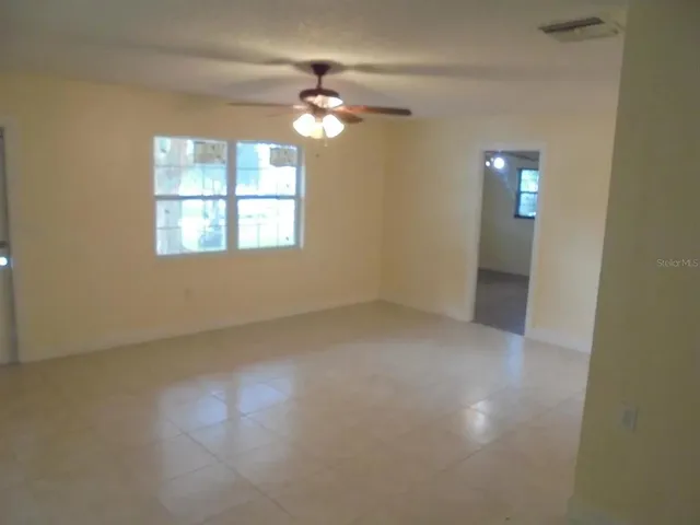 en empty room with windows and chandelier