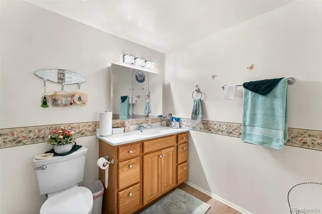 a bathroom with a granite countertop toilet sink and mirror