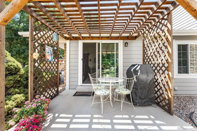 a patio with table and chairs and potted plants