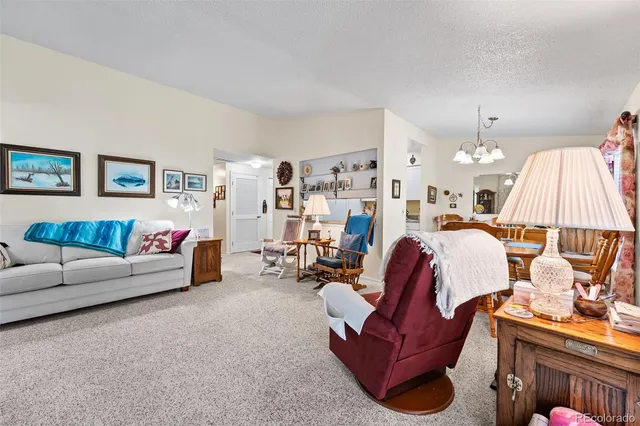 a living room with furniture and a chandelier