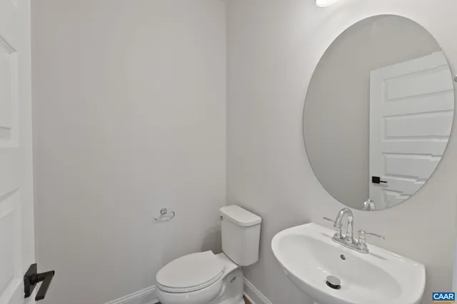 a bathroom with a sink a toilet and mirror