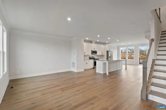 a view of kitchen with kitchen island wooden floor and center island