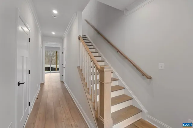 a view of a hallway with wooden floor and entryway