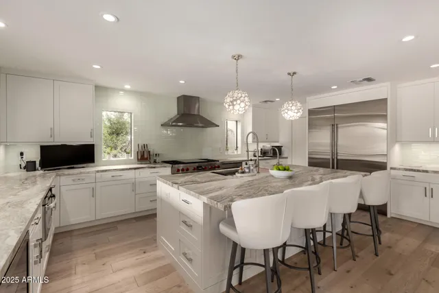 a large kitchen with kitchen island a sink table and chairs