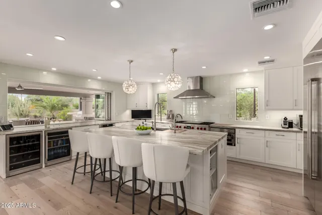 a kitchen with kitchen island a stove a sink a counter top space and a center island