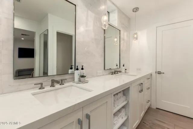 a bathroom with double sink and a mirror