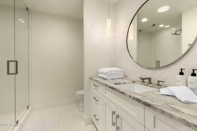 a bathroom with a granite countertop sink a toilet and a mirror