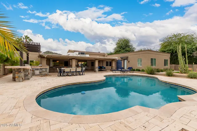 a view of a house with swimming pool and sitting area