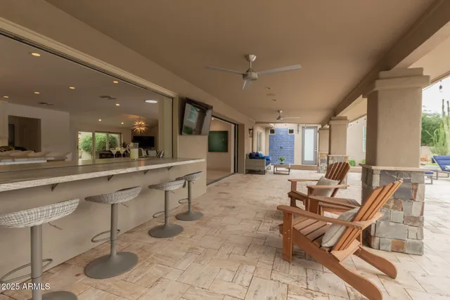 a living room with furniture a flat screen tv and a floor to ceiling window
