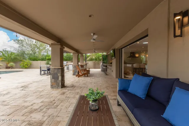 a view of a terrace with couches and pool view