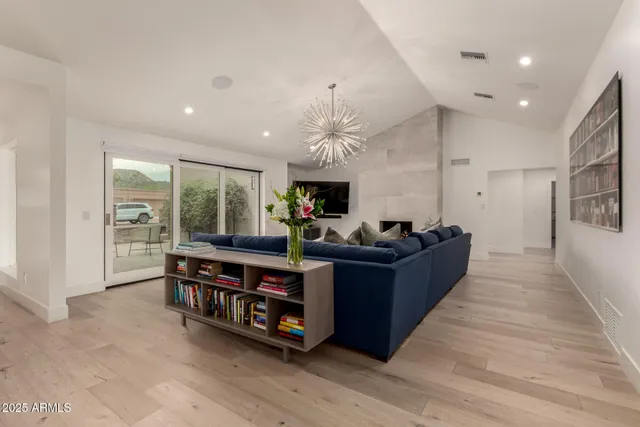 a living room with furniture a fireplace and a chandelier