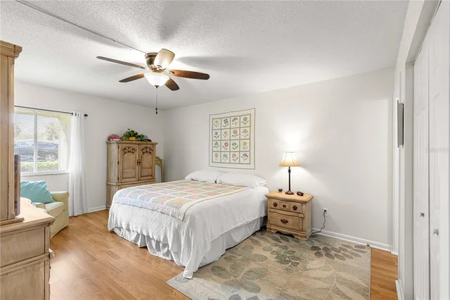 a spacious bedroom with a bed a couch and a chandelier