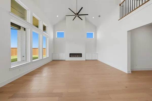 a view of an empty room with a window and a kitchen