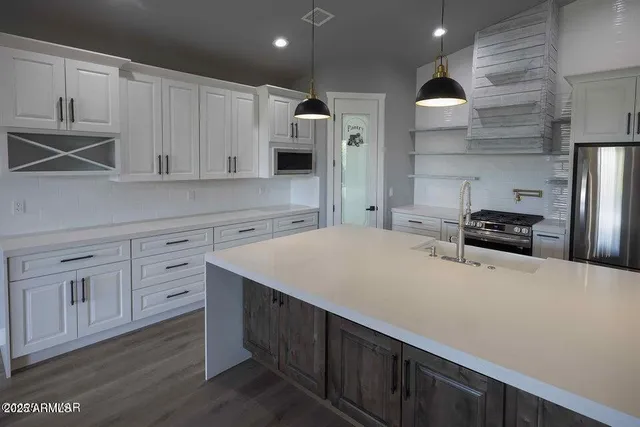 a kitchen with white cabinets and stainless steel appliances
