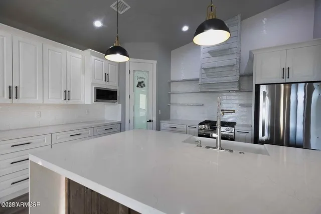 a kitchen with stainless steel appliances a refrigerator sink and cabinets