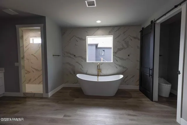 a spacious bathroom with a toilet and a shower