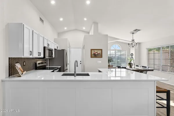 a large kitchen with kitchen island a sink stainless steel appliances and cabinets