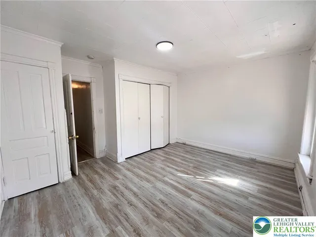 an empty room with wooden floor and closet