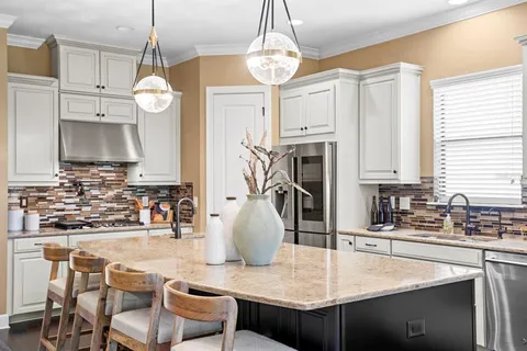 a kitchen with stainless steel appliances granite countertop a sink a stove and a wooden floor