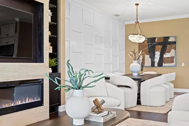 a living room with furniture a fireplace and a chandelier