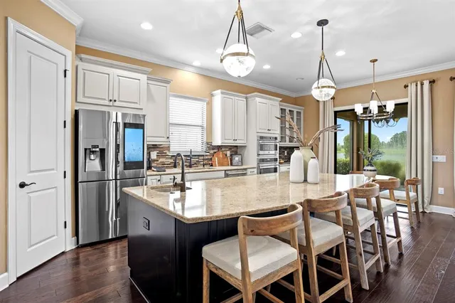 a kitchen with granite countertop a stove cabinets and dining table