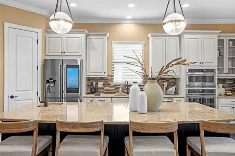 a kitchen with stainless steel appliances granite countertop a sink a stove and a table