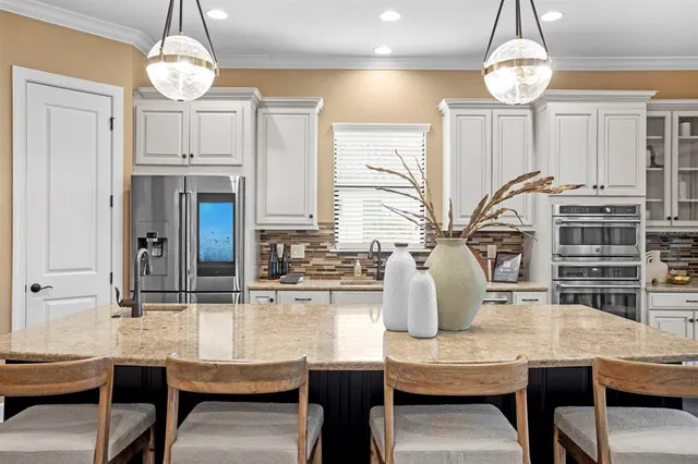 a kitchen with stainless steel appliances granite countertop a sink a stove and a table