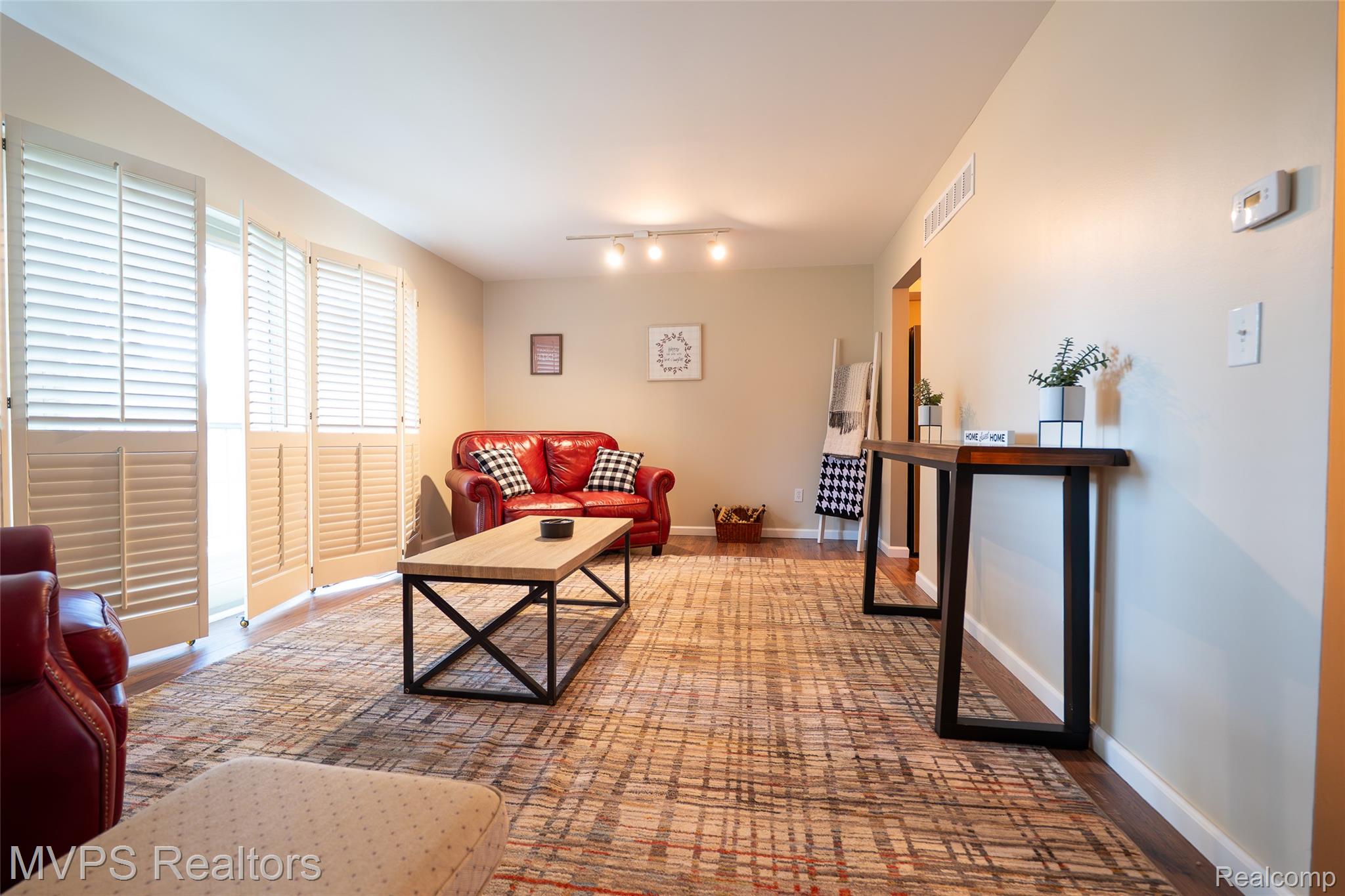 804 Oak Brook Ridge Drive, Unit 149 Rochester, MI 48307 - Photo 12 of 49 Spacious living area featuring wood-finish flooring, track lighting, and louvered bifold doors