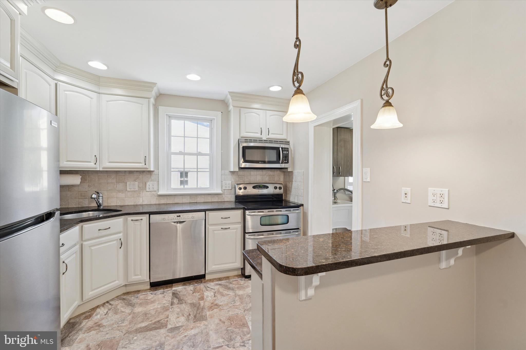 307 Madison Road Springfield, PA 19064 - Photo 7 of 29 a kitchen with stainless steel appliances granite countertop a sink a stove top oven a counter space and cabinets