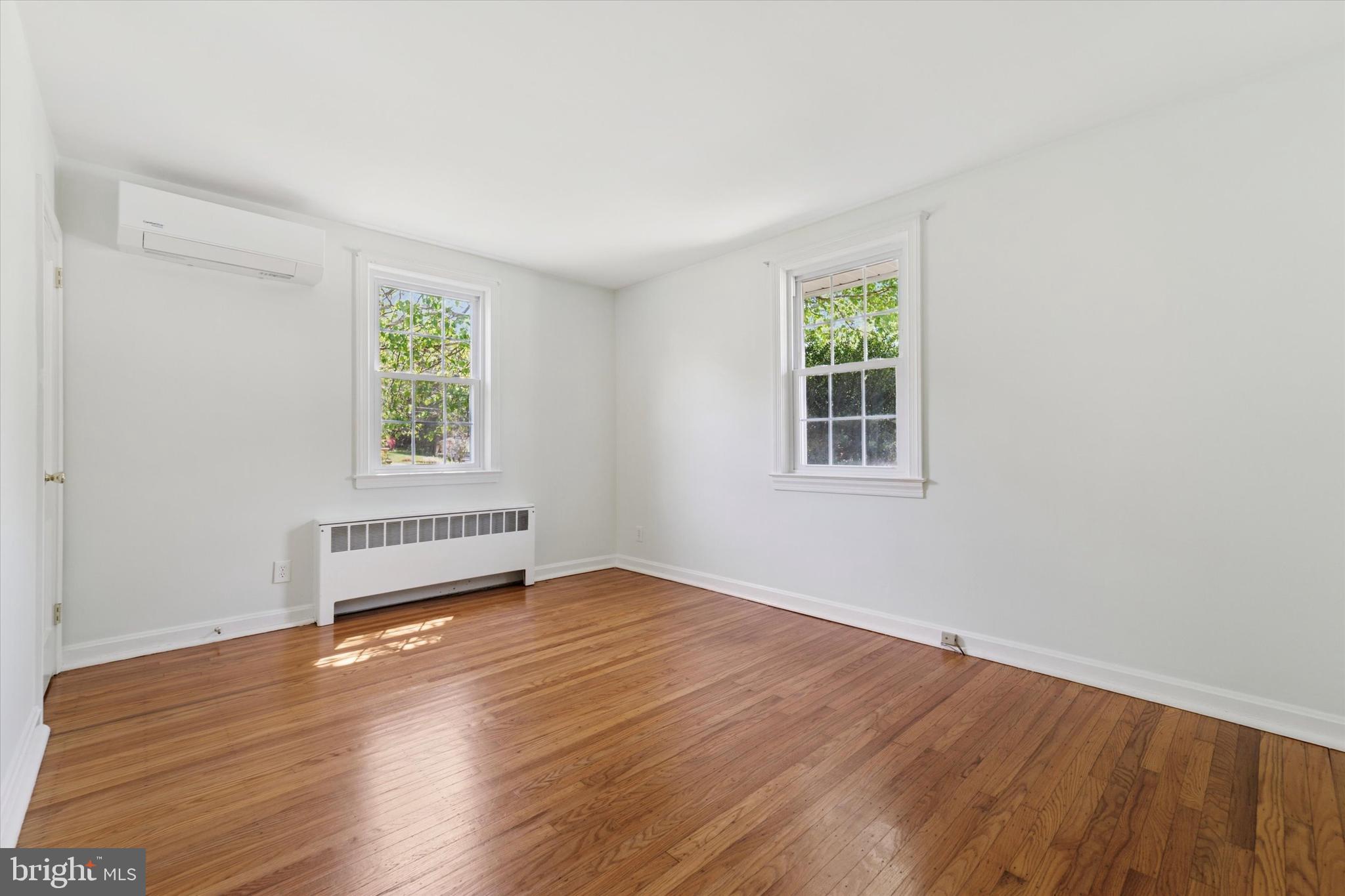 307 Madison Road Springfield, PA 19064 - Photo 9 of 29 an empty room with wooden floor and windows