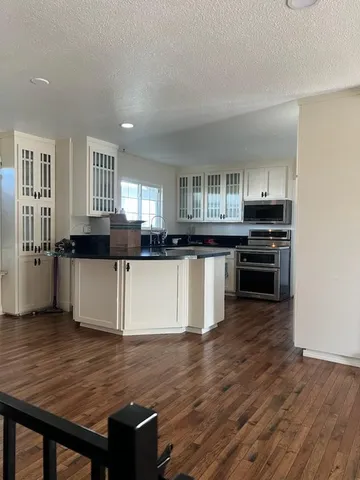 a kitchen with stainless steel appliances kitchen island granite countertop a stove a sink and a microwave