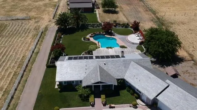 an aerial view of a house with yard swimming pool and outdoor seating