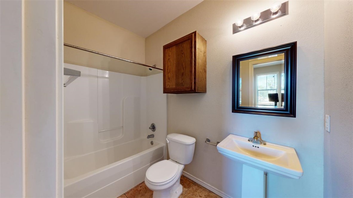 821 Ave B College Station, TX 77840 - Photo 22 of 33 a bathroom with a toilet sink vanity tub and mirror